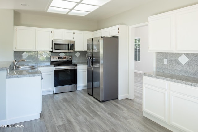 4734 Tierrapark Ct, Reno, NV 89502 - kitchen with appliances with stainless steel finishes, backsplash, white cabinets, and light wood-type flooring