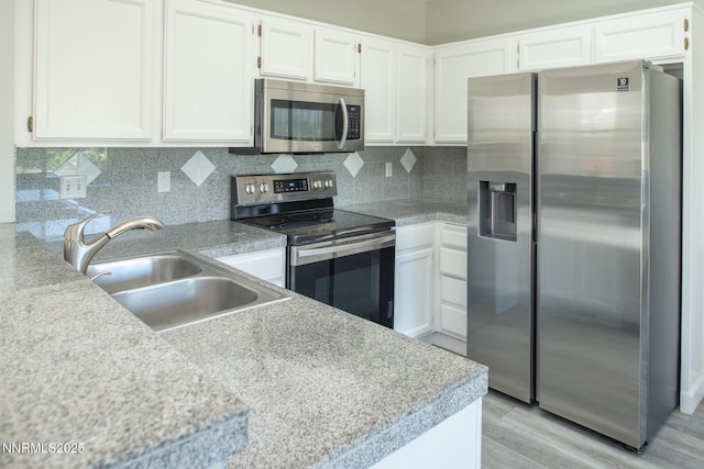 4734 Tierrapark Ct, Reno, NV 89502 - kitchen featuring appliances with stainless steel finishes, white cabinets, light countertops, light wood-style flooring, and backsplash