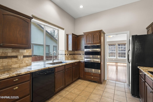 4175 Falling Water Dr, Reno, NV 89519 - kitchen featuring black appliances, a sink, backsplash, and light stone counters