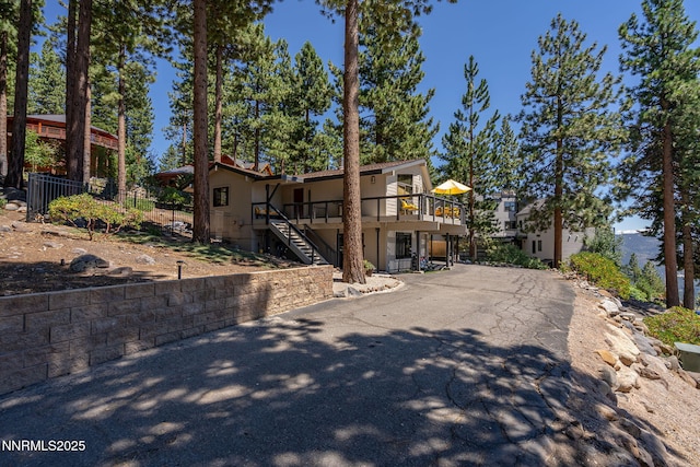 909 Tyner Way, Incline Village, NV 89451 - view of front facade with stairs, a wooden deck, and stucco siding