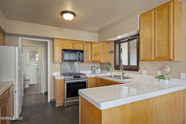 909 Tyner Way, Incline Village, NV 89451 - kitchen with black microwave, stainless steel gas stove, a sink, freestanding refrigerator, and a peninsula