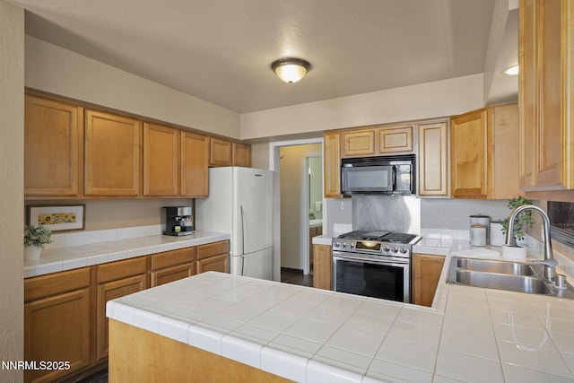 909 Tyner Way, Incline Village, NV 89451 - kitchen featuring black microwave, stainless steel range with gas stovetop, a sink, freestanding refrigerator, and a peninsula
