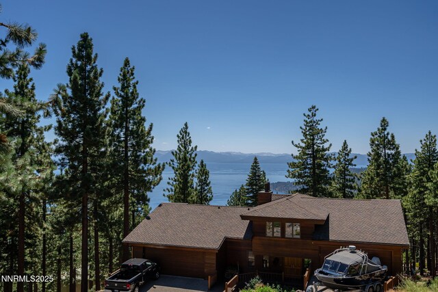 909 Tyner Way, Incline Village, NV 89451 - view of front of home with a mountain view, a chimney, a garage, and a shingled roof