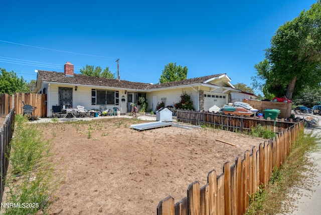 1650 Trabert Way, Sparks, NV 89431 - back of property with a garage, a fenced backyard, and a chimney