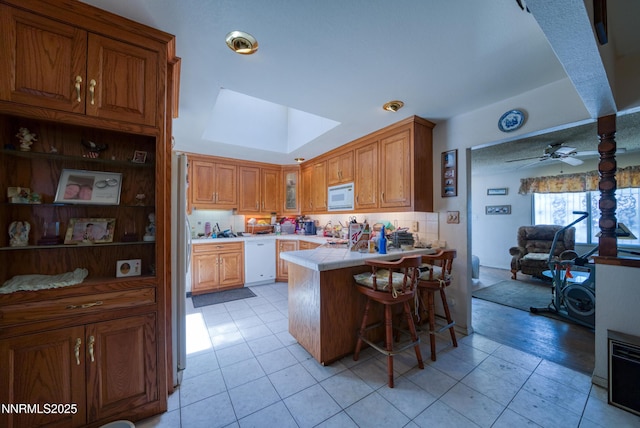 1650 Trabert Way, Sparks, NV 89431 - kitchen with white appliances, a peninsula, a kitchen breakfast bar, ceiling fan, and tile countertops
