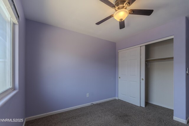 763 Canary Cir, Fernley, NV 89408 - unfurnished bedroom with dark colored carpet, baseboards, a ceiling fan, and a closet