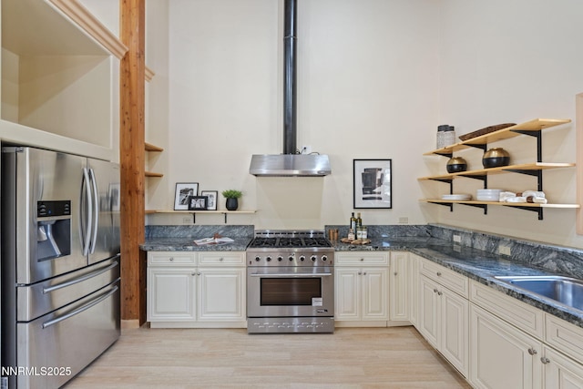 105 Rodeo Dr, Reno, NV 89508 - kitchen featuring stainless steel appliances, open shelves, light wood-style flooring, extractor fan, and dark stone countertops