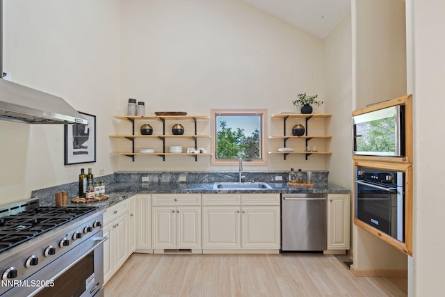 105 Rodeo Dr, Reno, NV 89508 - kitchen featuring stainless steel appliances, a sink, open shelves, light wood-type flooring, and dark stone counters