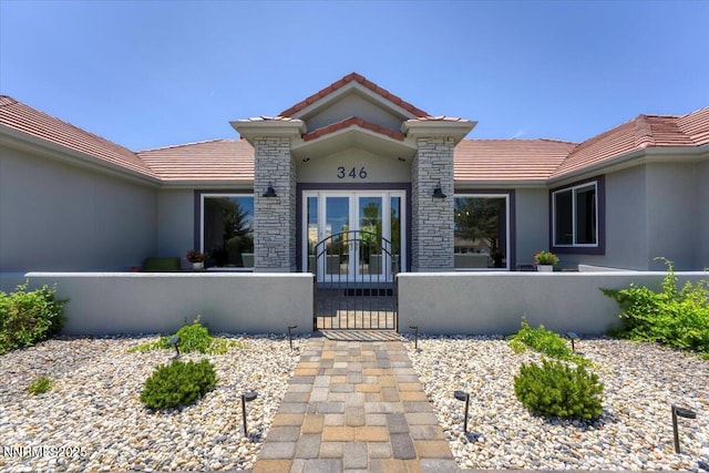 346 Wolf Run Ct, Reno, NV 89511 - doorway to property featuring a tile roof, stucco siding, a gate, and french doors