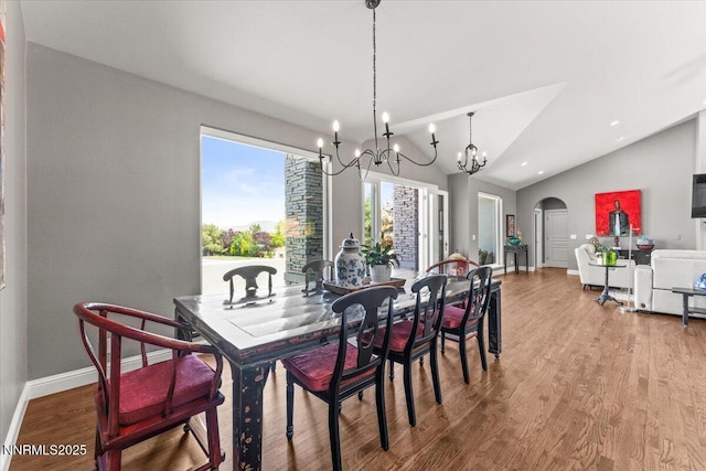346 Wolf Run Ct, Reno, NV 89511 - dining room featuring baseboards, arched walkways, a chandelier, wood finished floors, and lofted ceiling