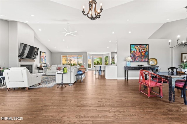 346 Wolf Run Ct, Reno, NV 89511 - living room featuring a chandelier, vaulted ceiling, wood finished floors, recessed lighting, and a glass covered fireplace