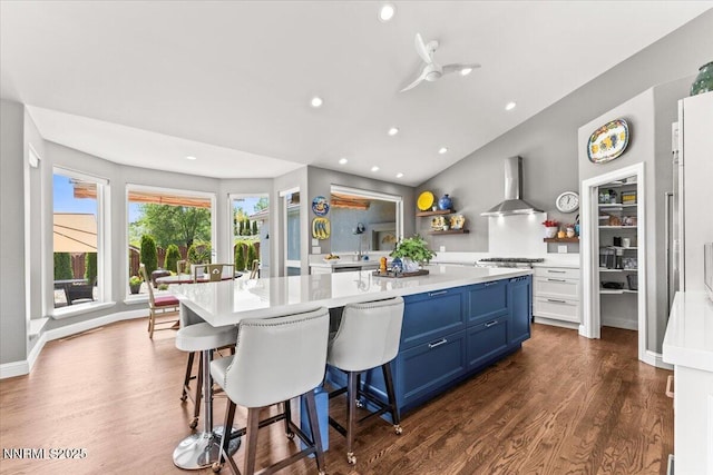 346 Wolf Run Ct, Reno, NV 89511 - kitchen with wall chimney exhaust hood, blue cabinetry, light countertops, dark wood-type flooring, and recessed lighting