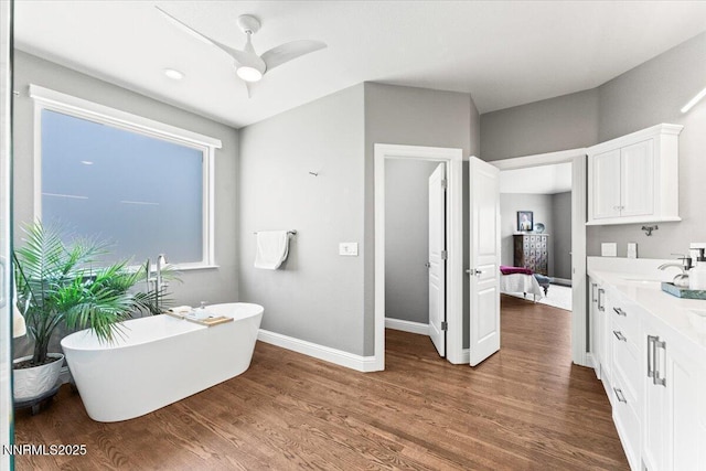 346 Wolf Run Ct, Reno, NV 89511 - ensuite bathroom featuring a freestanding tub, double vanity, wood finished floors, baseboards, and a ceiling fan