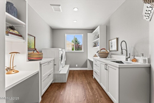 346 Wolf Run Ct, Reno, NV 89511 - washroom with washing machine and clothes dryer, dark wood-style flooring, baseboards, and cabinet space