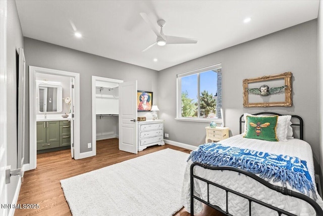 346 Wolf Run Ct, Reno, NV 89511 - bedroom featuring a walk in closet, baseboards, wood finished floors, a ceiling fan, and recessed lighting