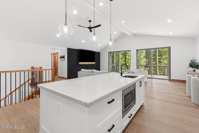 1877 Normuk St, South Lake Tahoe, CA 96150 - kitchen featuring open floor plan, stainless steel microwave, a sink, light wood-style flooring, and white cabinets