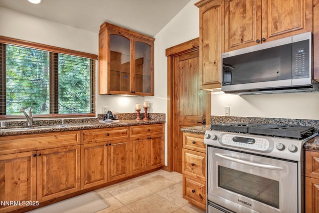886 Rosewood Cir, Incline Village, NV 89451 - kitchen featuring stainless steel appliances, a sink, dark stone countertops, brown cabinetry, and glass insert cabinets