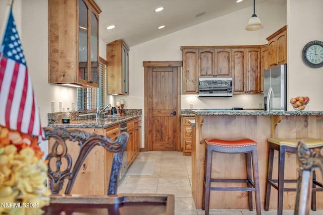 886 Rosewood Cir, Incline Village, NV 89451 - kitchen with appliances with stainless steel finishes, lofted ceiling, dark stone counters, recessed lighting, and a kitchen breakfast bar