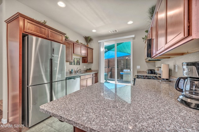 3678 Hollywood Park Dr, Reno, NV 89512 - kitchen featuring stainless steel appliances, brown cabinets, a sink, a peninsula, and recessed lighting