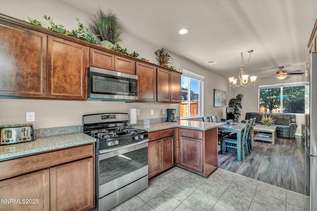 3678 Hollywood Park Dr, Reno, NV 89512 - kitchen featuring appliances with stainless steel finishes, a chandelier, light tile patterned floors, recessed lighting, and a peninsula