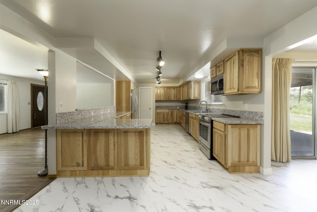 4879 Idlewild Dr, Reno, NV 89519 - kitchen with appliances with stainless steel finishes, light stone counters, a peninsula, and light marble finish floors