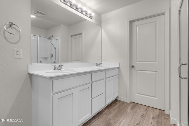 503 Astraea Trl, Reno, NV 89506 - bathroom featuring double vanity, a shower with shower door, and wood finished floors