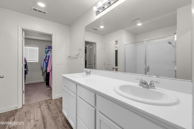 503 Astraea Trl, Reno, NV 89506 - full bathroom featuring a stall shower, wood finished floors, double vanity, a spacious closet, and baseboards