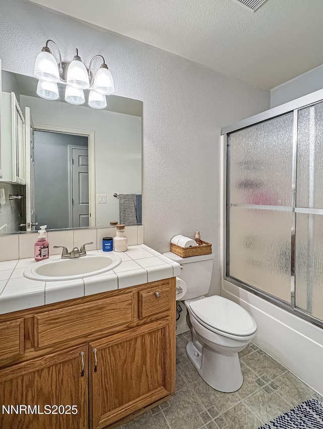 602 Tamsen Rd, Fernley, NV 89408 - full bathroom featuring toilet, vanity, a textured wall, bath / shower combo with glass door, and a textured ceiling