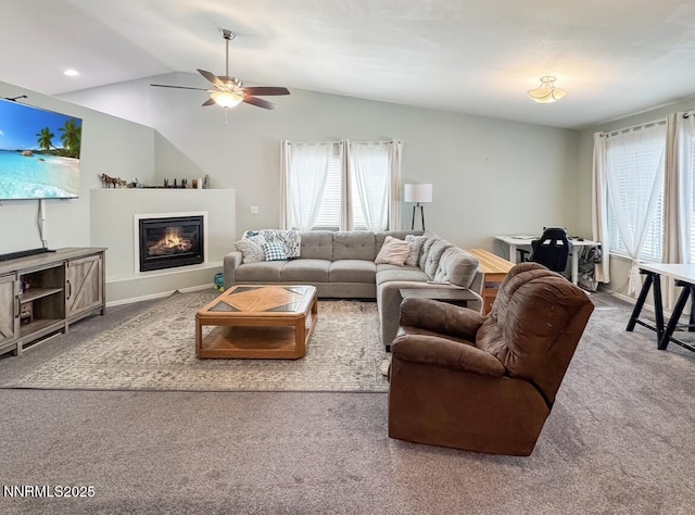 602 Tamsen Rd, Fernley, NV 89408 - carpeted living area with vaulted ceiling, a ceiling fan, a glass covered fireplace, and baseboards