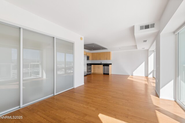 255 N Sierra St Unit 1210, Reno, NV 89501 - unfurnished living room featuring light wood finished floors and a raised ceiling
