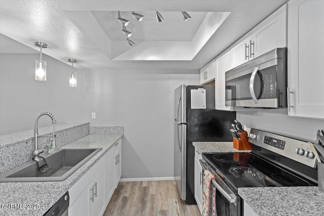 423 Barclay Ct, Reno, NV 89511 - kitchen featuring appliances with stainless steel finishes, a sink, light wood-style flooring, white cabinets, and a raised ceiling
