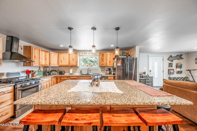 9365 Gremlin Way, Reno, NV 89506 - kitchen with appliances with stainless steel finishes, wall chimney range hood, light brown cabinets, a kitchen breakfast bar, and light stone counters