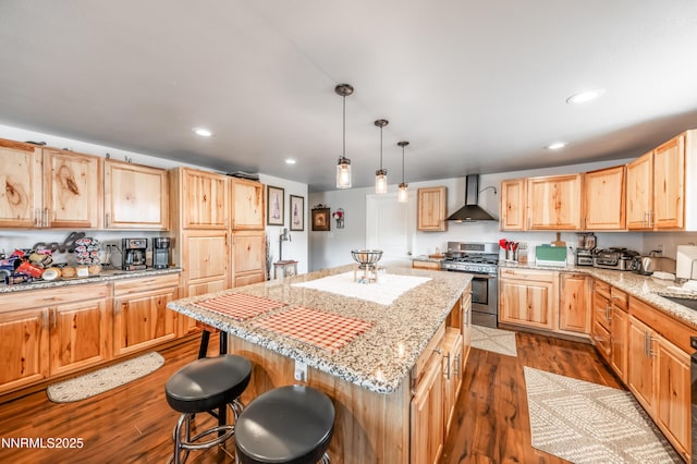 9365 Gremlin Way, Reno, NV 89506 - kitchen with gas stove, wall chimney exhaust hood, light brown cabinetry, dark wood finished floors, and a breakfast bar