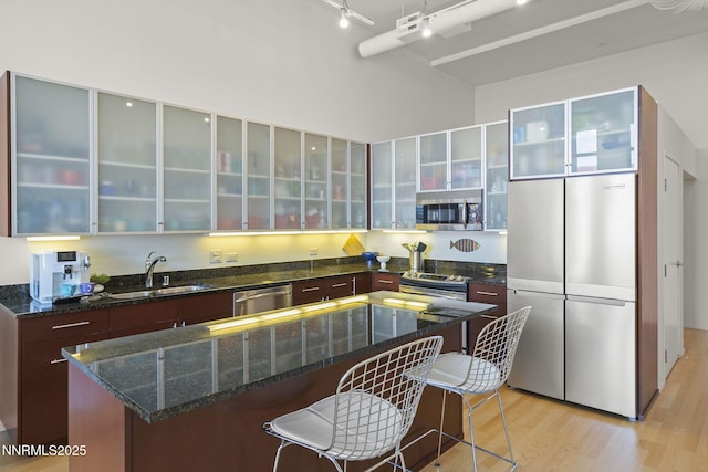 255 N Sierra St Unit 305, Reno, NV 89501 - kitchen featuring appliances with stainless steel finishes, modern cabinets, light wood-style floors, track lighting, and a breakfast bar