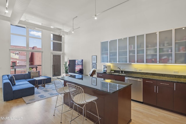 255 N Sierra St Unit 305, Reno, NV 89501 - kitchen with dishwasher, a high ceiling, light wood-type flooring, a breakfast bar area, and a kitchen island