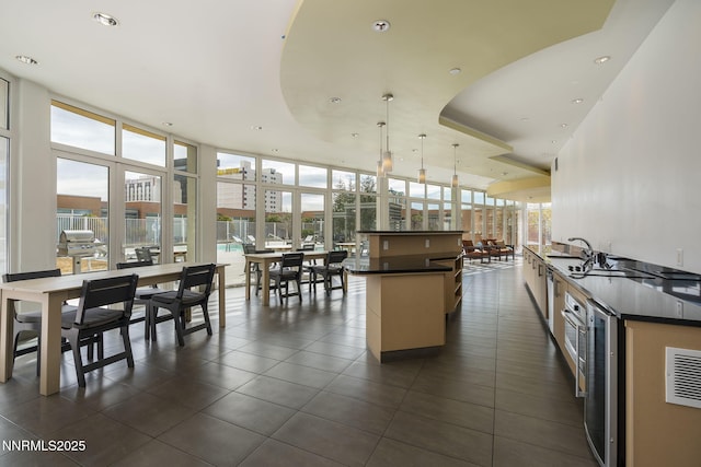 255 N Sierra St Unit 305, Reno, NV 89501 - kitchen with dark countertops, dark tile patterned flooring, expansive windows, beverage cooler, and a center island