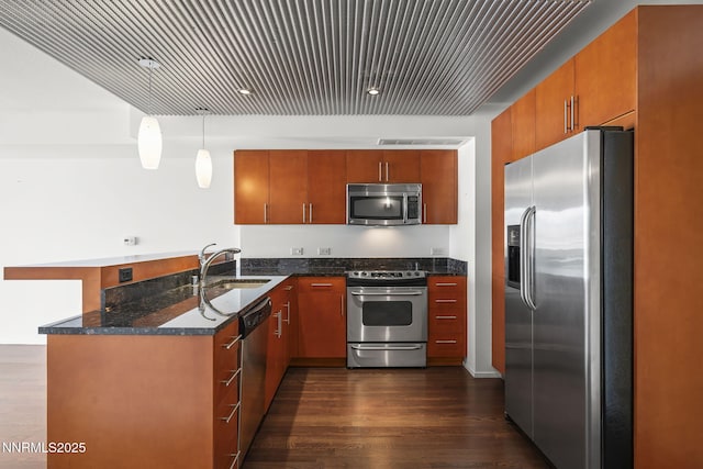 255 N Sierra St Unit 2113, Reno, NV 89501 - kitchen with appliances with stainless steel finishes, a peninsula, dark wood-type flooring, dark stone countertops, and pendant lighting