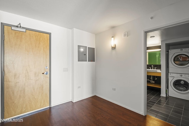 255 N Sierra St Unit 2113, Reno, NV 89501 - laundry area featuring estacked washer and dryer, dark wood-style flooring, and electric panel