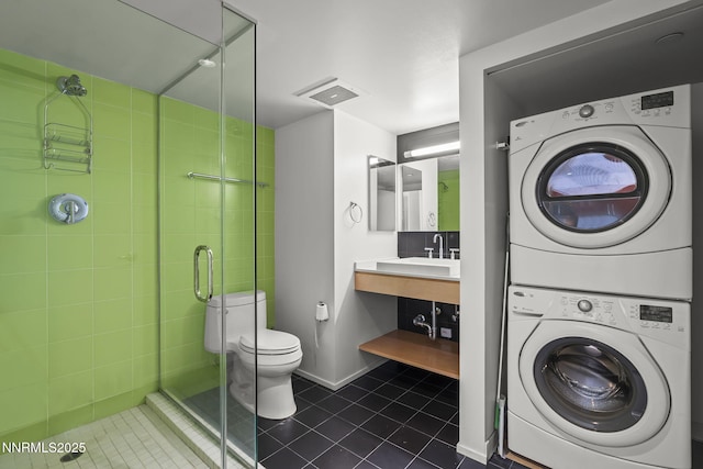 255 N Sierra St Unit 2113, Reno, NV 89501 - washroom featuring stacked washer and clothes dryer and dark tile patterned floors