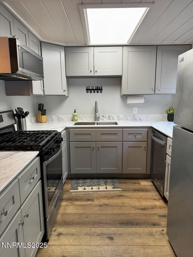 810 Alder Ave Unit 61, Incline Village, NV 89451 - kitchen featuring appliances with stainless steel finishes, a sink, gray cabinetry, wood finished floors, and light stone counters