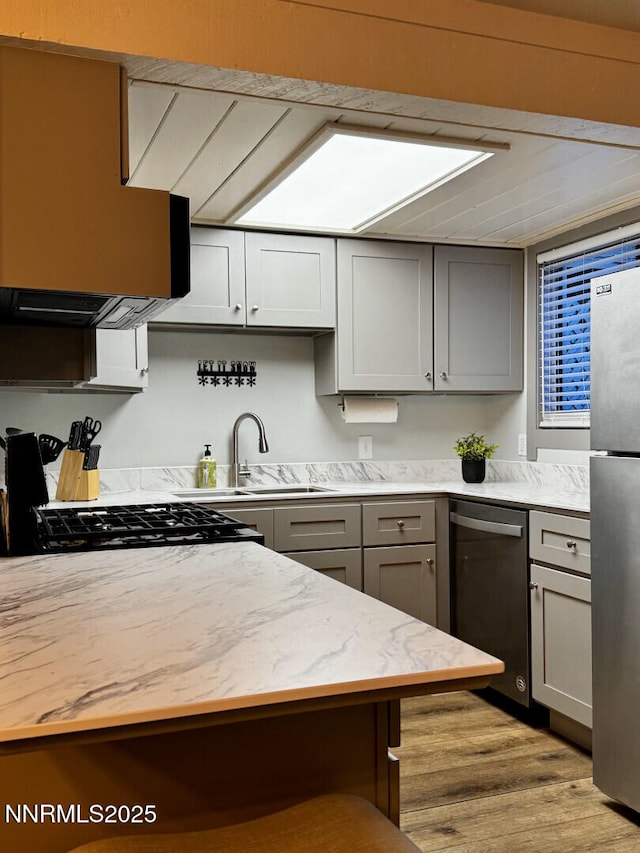 810 Alder Ave Unit 61, Incline Village, NV 89451 - kitchen featuring stainless steel appliances, gray cabinetry, wood finished floors, a sink, and exhaust hood