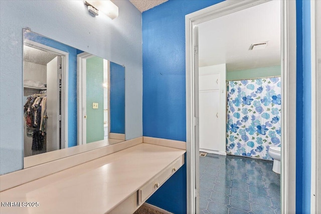 4415 Leche Way, Reno, NV 89502 - full bath with toilet, a walk in closet, vanity, and a textured ceiling