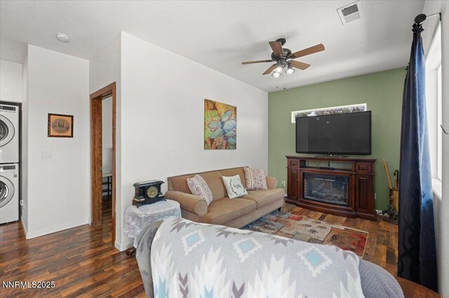 1055 Golden Park Way, Fallon, NV 89406 - living room with estacked washer and dryer, ceiling fan, wood finished floors, and baseboards