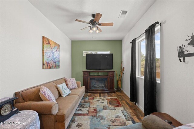1055 Golden Park Way, Fallon, NV 89406 - living area with wood finished floors, a ceiling fan, and a glass covered fireplace