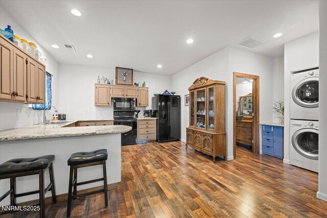 1055 Golden Park Way, Fallon, NV 89406 - kitchen featuring black appliances, stacked washing machine and dryer, a peninsula, dark wood finished floors, and recessed lighting