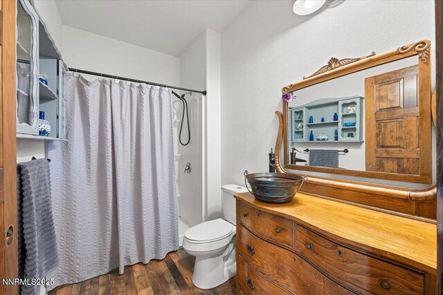 1055 Golden Park Way, Fallon, NV 89406 - full bath with vanity, wood finished floors, toilet, and shower / bath combination with curtain