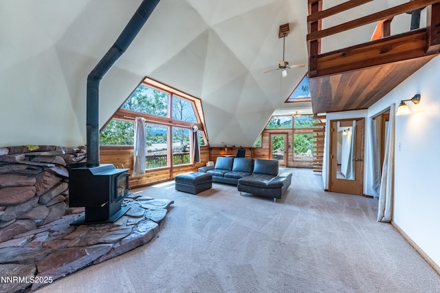 15118 N Timberline Dr, Reno, NV 89511 - carpeted living room with plenty of natural light, a ceiling fan, a wood stove, high vaulted ceiling, and wooden walls
