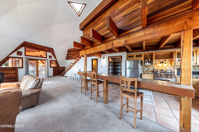 15118 N Timberline Dr, Reno, NV 89511 - dining space featuring stairs, light carpet, light tile patterned flooring, a towering ceiling, and wood ceiling with exposed beams