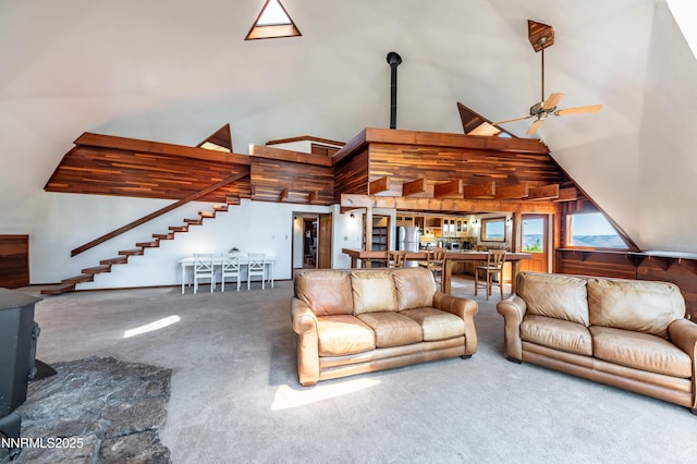 15118 N Timberline Dr, Reno, NV 89511 - carpeted living room with high vaulted ceiling, a wood stove, a ceiling fan, and stairs