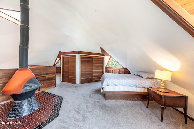 15118 N Timberline Dr, Reno, NV 89511 - bedroom with vaulted ceiling, a wood stove, and carpet flooring